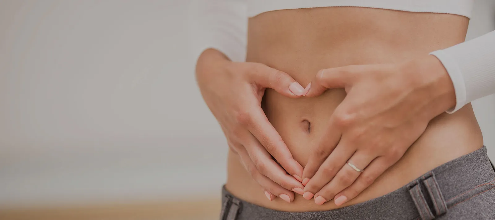 Woman forming a heart shape over her stomach